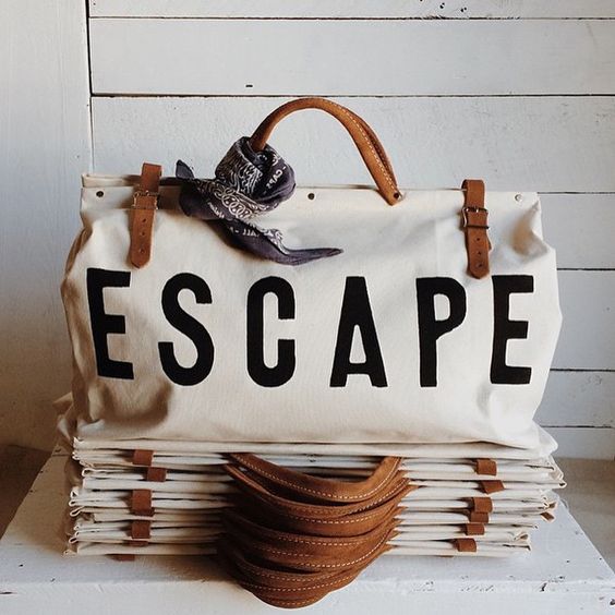Bag with "ESCAPE" text and leather straps.