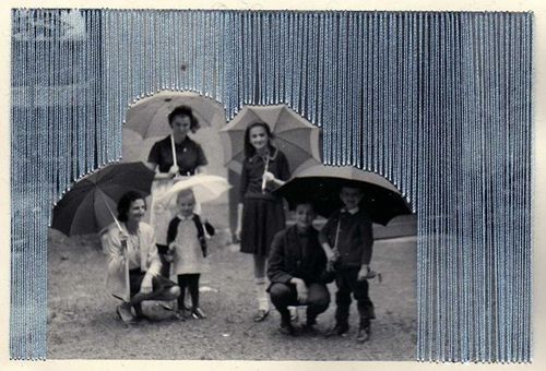 People with umbrellas, partially obscured by embroidery.