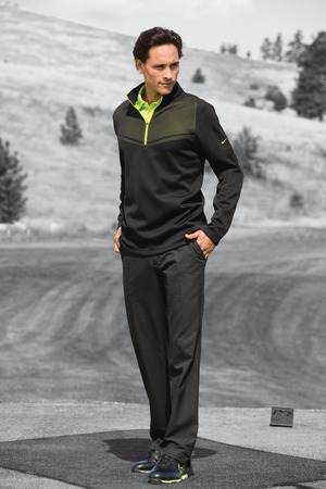 Man wearing black outfit on golf course.