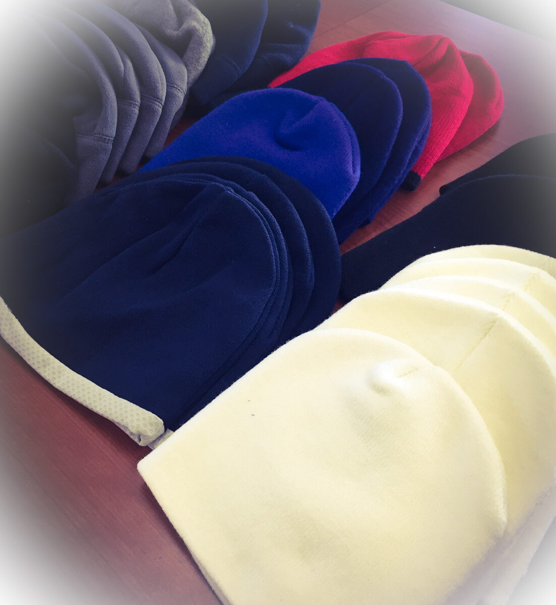Colorful beanies arranged on a table.