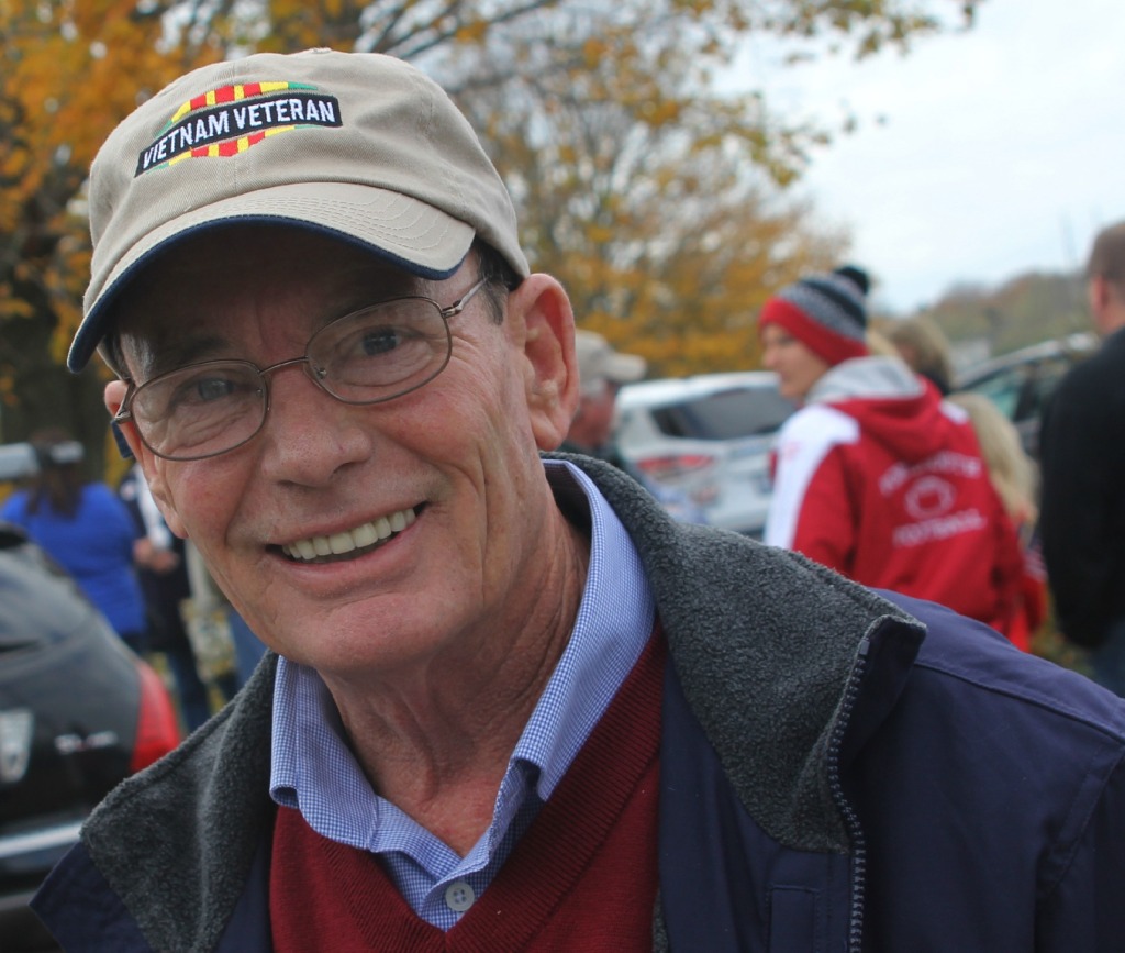 Smiling man wearing Vietnam Veteran cap.