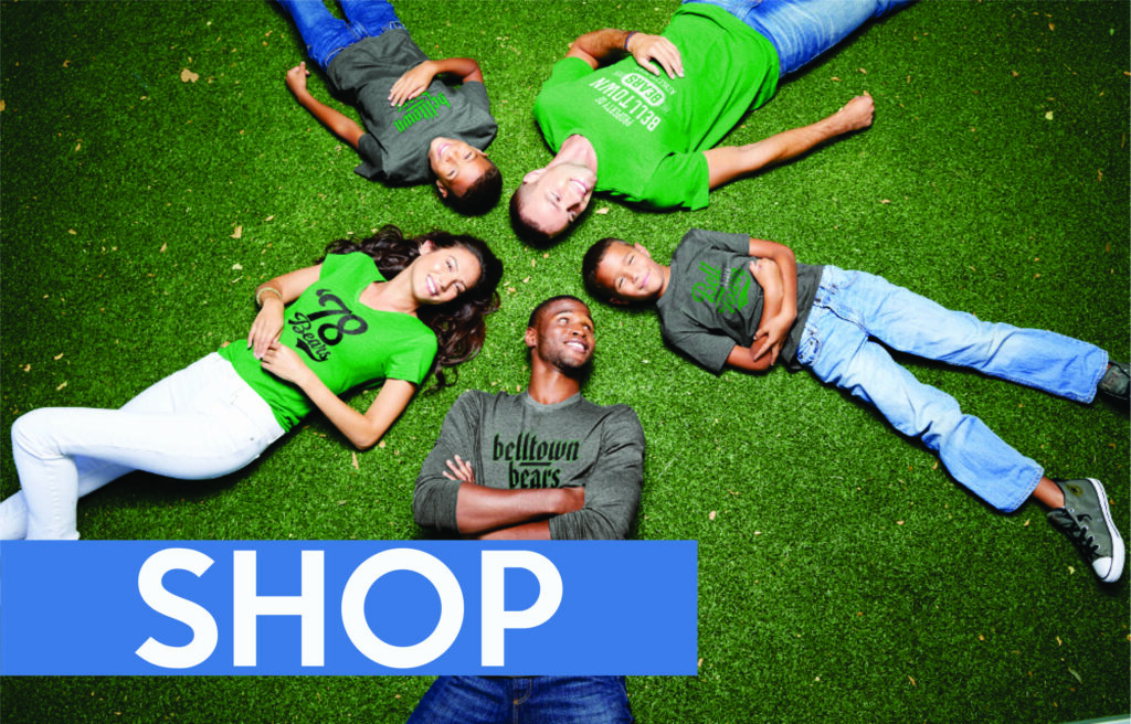 Family lying on grass with "Shop" text.