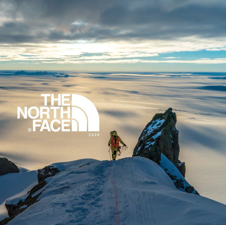 Climber on snowy ridge, dramatic landscape background.