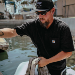 Man handling rope on a boat dock.