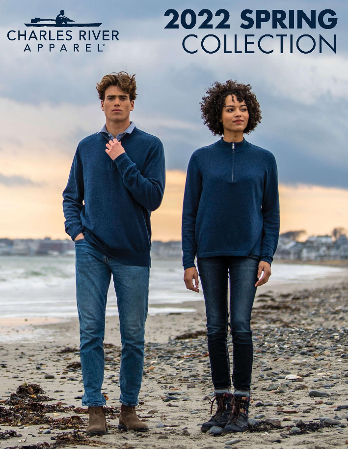 Models wearing blue sweaters on beach.