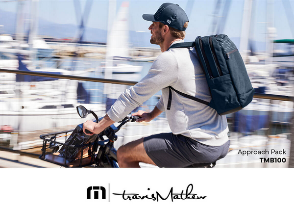 Man cycling with backpack near marina.